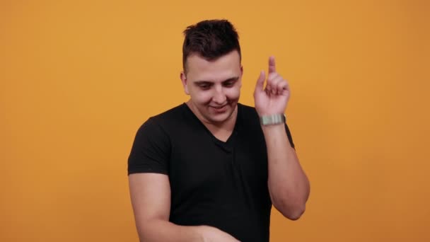 Handsome young man dancing, keeping fingers ip, smiling. - Záběry, video