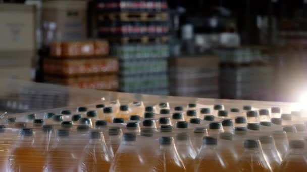 Geautomatiseerde verpakking batch flessen in drankfabriek met plastic wrap closeup - Video