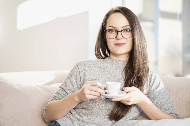 Portrait of smiling young woman starting her day with a cup of coffee. - Fotoğraf, Görsel