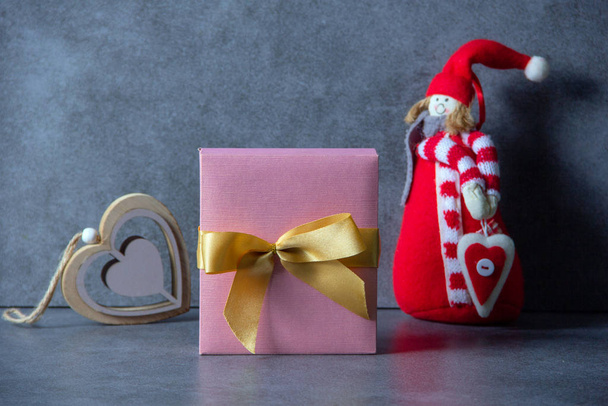 Red soft toy, gift box decorated with a golden bow, wooden decorative heart on a dark background. Valentines day concept. Happy birthday or anniversary congratulation. Copy space. Horizontal view. - Fotografie, Obrázek