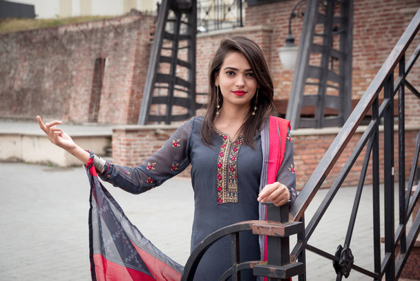 Μια Ινδή στέκεται στο δρόμο της πόλης. Κορίτσι με παραδοσιακά ινδικά ρούχα, Salwar kameez. - Φωτογραφία, εικόνα