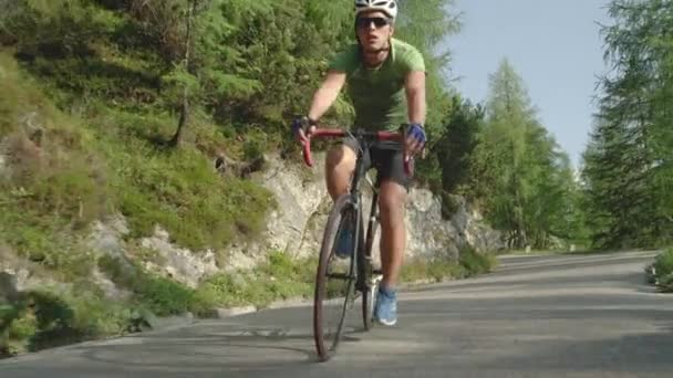 Lassú mozgás: fiatal közúti kerékpáros száguld végig az erdei úton az új kerékpárjával. - Felvétel, videó