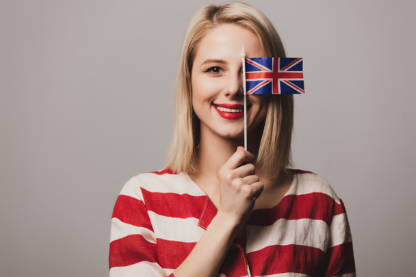 beatiful girl holds British flag on gray background - Zdjęcie, obraz