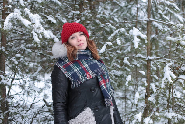 młoda kobieta z rudymi włosami na zimowym spacerze w lesie zimna pogoda i dobry nastrój romantyczny - Zdjęcie, obraz