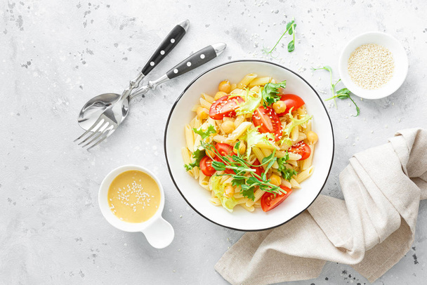 Pasta salad with fresh tomato, chickpea, lettuce and pea sprouts in lunch bowl - Foto, Bild