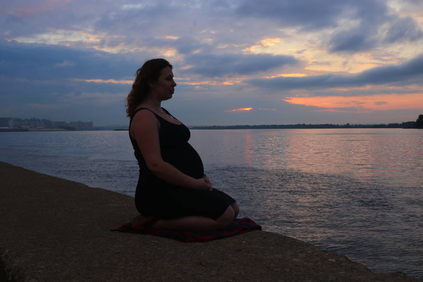 молода жінка з кучерявим рудим волоссям на дев'ятому місяці вагітності
 - Фото, зображення