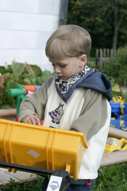 boy is honking with the toy excavator - Zdjęcie, obraz