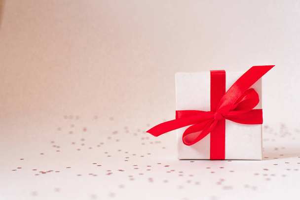 Caja de regalo con cinta roja y corazón de vidrio sobre fondo blanco para
 - Foto, imagen