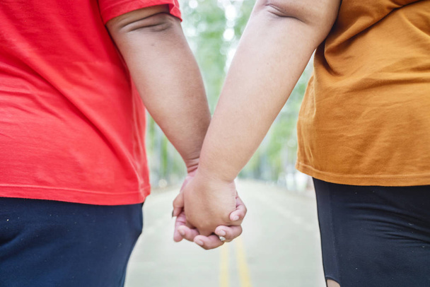 Closeup of unidentified fat couple holding hands - Фото, зображення