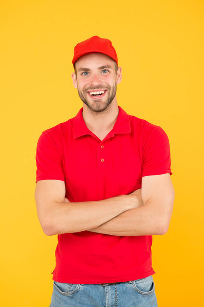 Courier and delivery service. Postman delivery worker. Man red cap yellow background. Delivering purchase. Already ready. Easing your business. Service delivery. Salesman and courier career - Fotografie, Obrázek