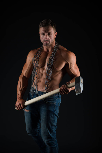 Brutality concept. Bodybuilder concept. Healthy and strong. Attractive guy muscular body. Bodybuilder brutal guy. Man fitness training with heavy hammer. Mining industry. Coal miner workshop - Foto, afbeelding