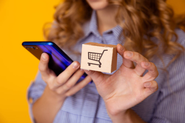 Online-Shopping. Papierschachteln in Frauenhand und Telefon. Lieferservice-Konzept. - Foto, Bild