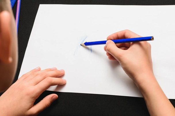 Uczeń rysuje ołówki na białym papierze.. - Zdjęcie, obraz