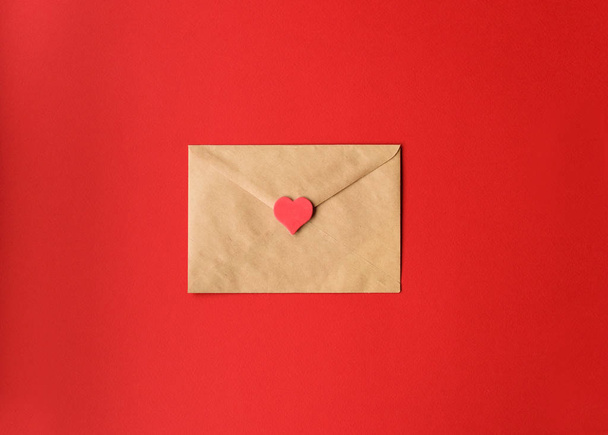 St. Valentine's love letter of craft paper with red heart on red background with copy space. Horizontal. - Fotoğraf, Görsel