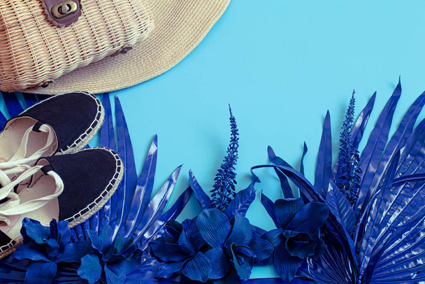 Akcesoria letnie, buty i kapelusz z torbą na niebieskim tle. - Zdjęcie, obraz