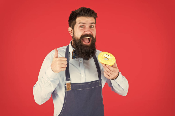 baker hold donut. Funny hipster. Sweet donut. Chef man in cafe. Diet and healthy food. Doughnut diet. Calorie. Feel hunger. Perfect donut. Bearded man in apron. Donut food. I love my job. - Fotó, kép
