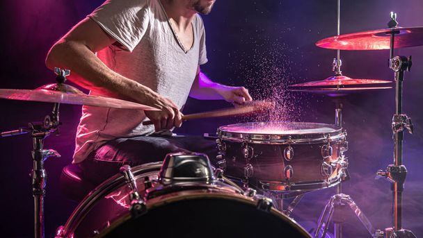 Барабанщик играет на барабанах. Красивый синий и красный фон
,  - Фото, изображение