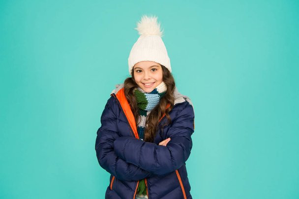 Keep your baby really warm whilst active. Happy baby girl with confident smile. Little baby keep arms crossed blue background. Small baby enjoy casual winter style. Fashion and style - Φωτογραφία, εικόνα
