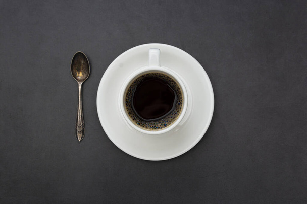 Coffee. White cup of coffee top view spoon and plate on dark background - Zdjęcie, obraz