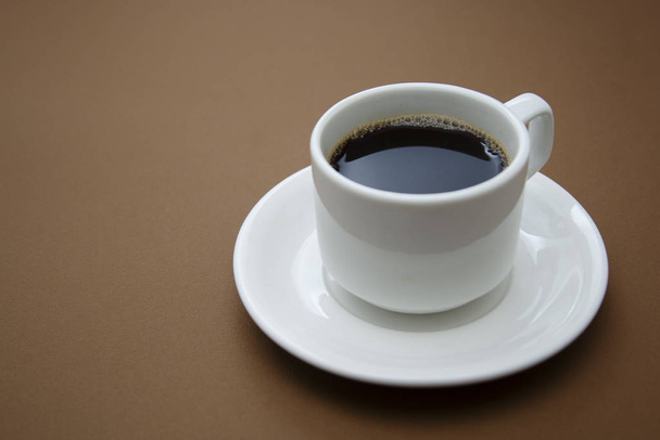 Coffee cup isolated on brown table. Coffee drink with copy space. - Zdjęcie, obraz