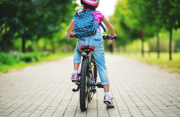 щаслива Весела дитина дівчина їде на велосипеді в парк в натур - Фото, зображення