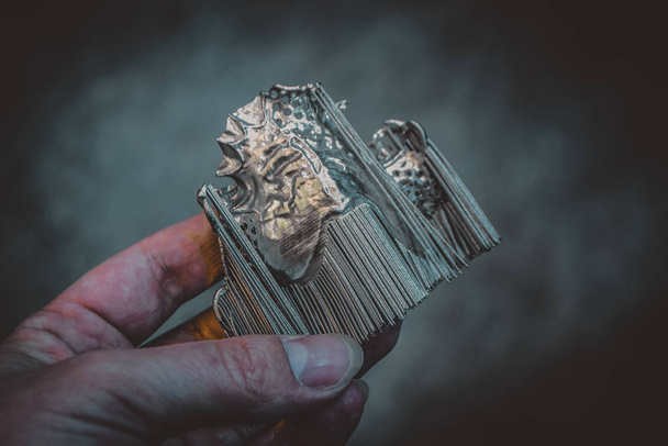 Člověk drží objekt vytištěný na kovové 3D tiskárně. - Fotografie, Obrázek