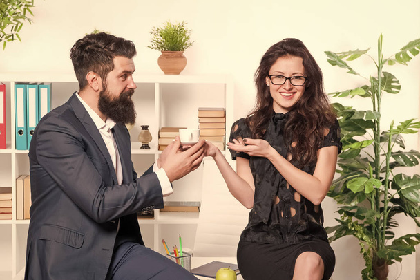 Bearded man and attractive woman. Man and woman conversation coffee time. Office rumors. Office coffee. Couple coworkers relax coffee break. Share coffee with with colleague. Flirting colleagues - Zdjęcie, obraz
