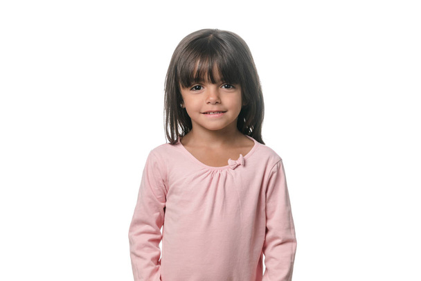 Portrait d'une petite fille brune posant isolée sur fond blanc
. - Photo, image