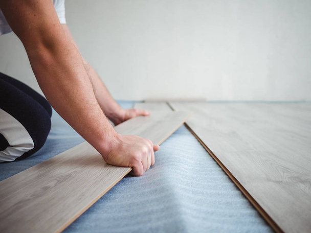 The repair process in the apartment. Man laying laminate flooring - Foto, Imagem