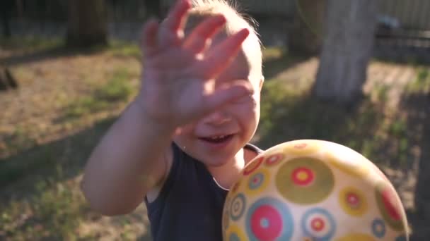 Little boy runs with the ball in his hands and smile in slow motion. - Video