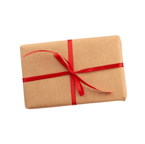 obdélníková krabice zabalená v hnědém papíru a svázaná červenou mašlí,  - Fotografie, Obrázek