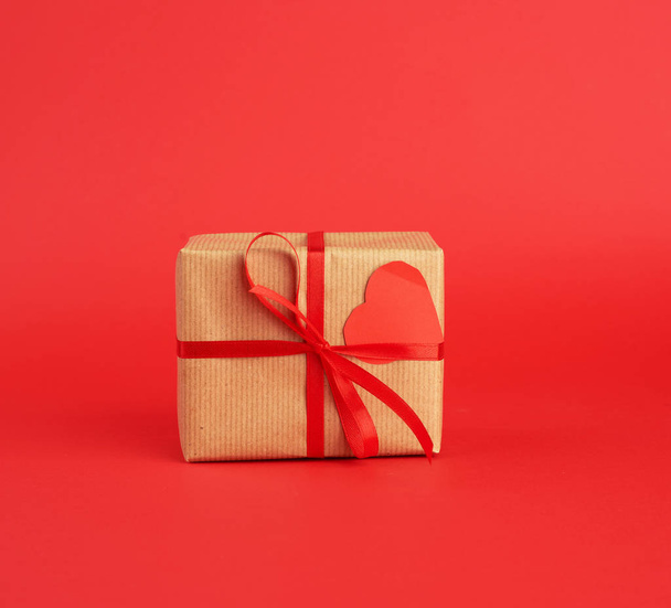 wrapped square box with a gift in brown craft paper and tied wit - Fotoğraf, Görsel