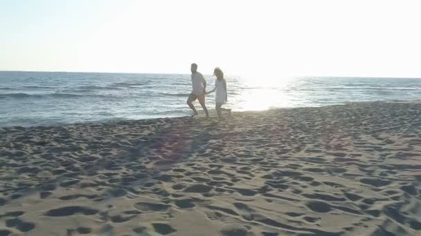 aerial view of couple having fun running along the beach near the water - Footage, Video