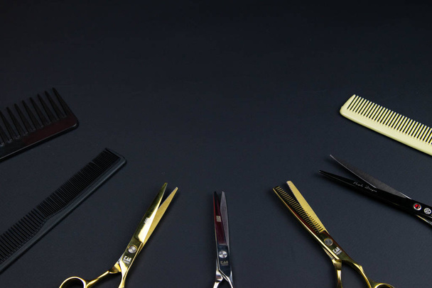 Composición de instrumentos peluqueros sobre fondo texturizado negro
 - Foto, imagen