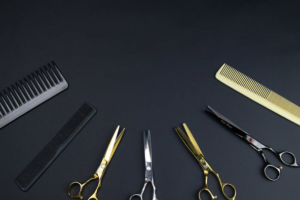 Composición de instrumentos peluqueros sobre fondo texturizado negro
 - Foto, imagen