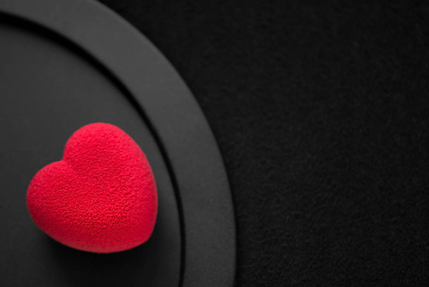 Valentines day concept. Red heart-shaped velvet cake on a black background.   - Photo, image