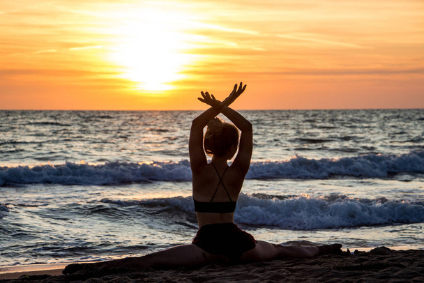 Osamělý tanečník balet pózující na pláži západ slunce silueta moře - Fotografie, Obrázek