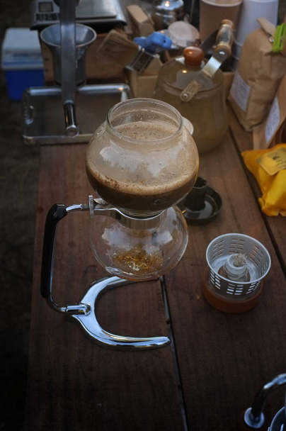 Close up of hot coffee brewing gadgets on wooden table counter. - Photo, Image