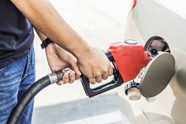 image of a man hands pumping gasoline fuel in car at the gas station, self-service, concept - Φωτογραφία, εικόνα