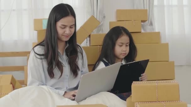 Die asiatischen Schwestern und Schwestern nutzen einen Laptop, um die Produkte zu überprüfen, die an die Kunden geschickt werden müssen. zu Hause, sme, das neue Geschäftskonzept. - Filmmaterial, Video
