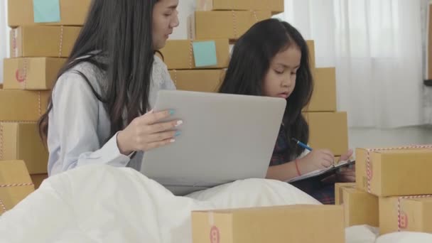 Aziatische zusters en zusters gebruiken een laptop om de producten te controleren die naar klanten gestuurd moeten worden. Thuis, Sme, het nieuwe business concept. - Video