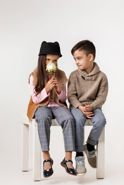Cute stylish little couple child girl and boy sittting together . - 写真・画像