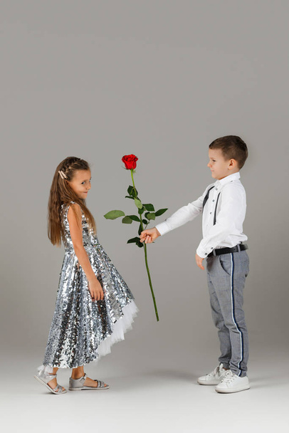 little boy giving a red rose to child girl - Fotoğraf, Görsel