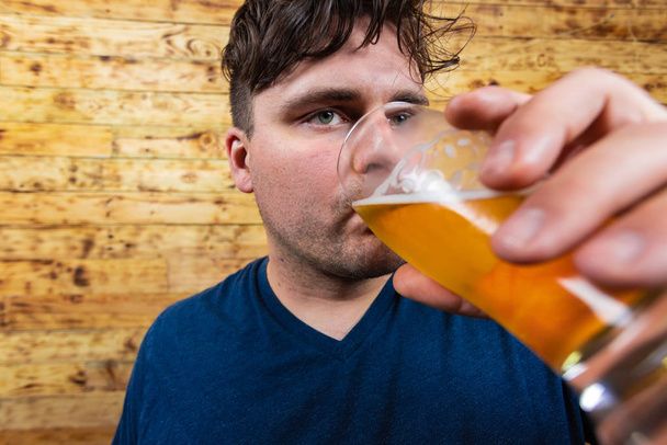 思慮深い男性のビールを飲むの肖像。男性はビールを飲む。若い男がビールを飲んで夢を見て. - 写真・画像