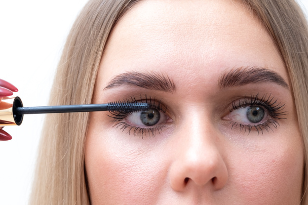 Female eyes with mascara brush. Female eyes with long eyelashes and a mascara brush. - Photo, Image