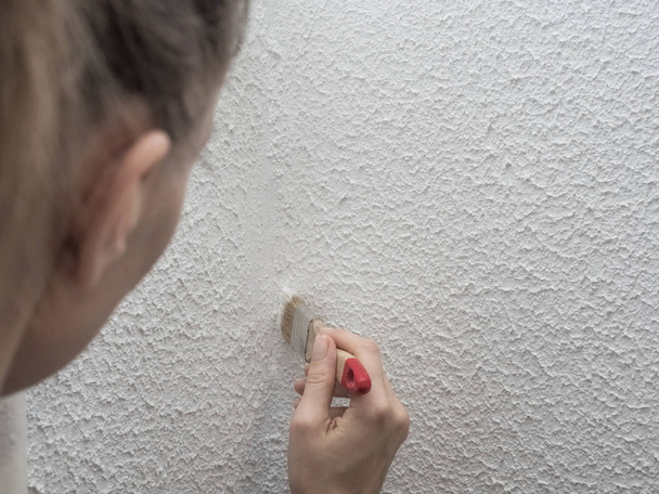 Женщина красит стену. Реставрация окрашенных белых стен
 - Фото, изображение