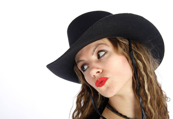 beautiful young woman in black hat and red lips posing in studio on white background - Photo, image