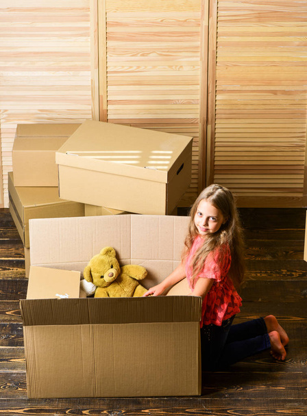 Happy childhood. Relocating family stressful for kids. Kid girl relocating boxes background. Relocating concept. Delivery service. Box package and storage. Small child prepare toys for relocation - Fotoğraf, Görsel
