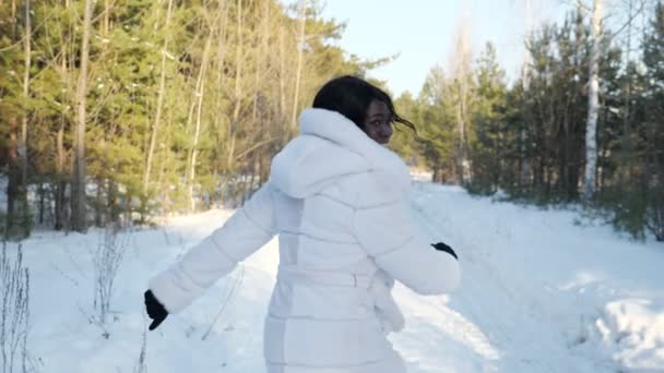 donna dalla pelle scura corre lungo il sentiero forestale guardando indietro
 - Filmati, video