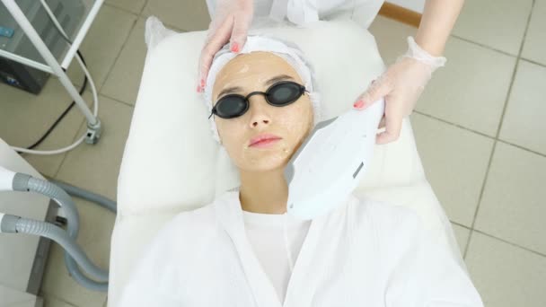 νεαρή γυναίκα με ειδικά μαύρα γυαλιά ξαπλώνει σε λευκό καναπέ - Πλάνα, βίντεο